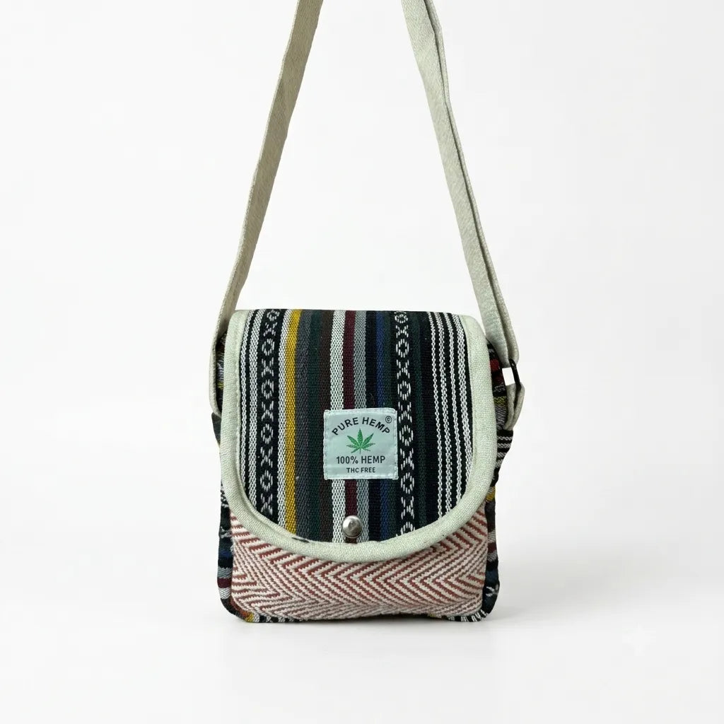 Yatra hemp sling bag front view with the metal snap-button flap closed over the natural beige hemp body