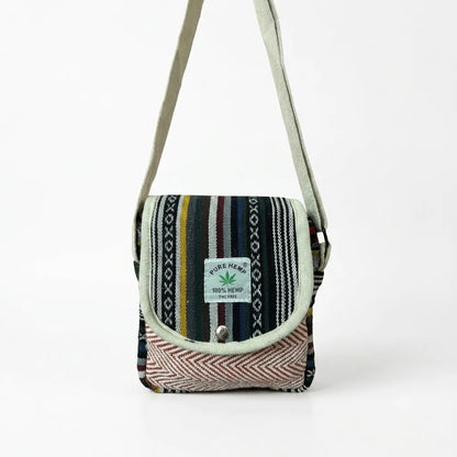 Yatra hemp sling bag front view with the metal snap-button flap closed over the natural beige hemp body